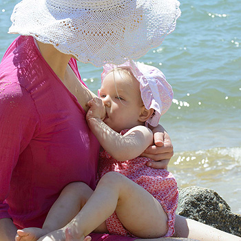 Maman allaite sur la plage